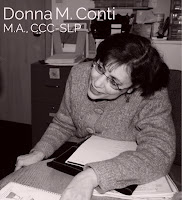 Donna M. Conti, M.A., CCC-SLP, writing at a desk in a black and white photo