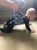 Baby in a crawling position on a carpet looking ahead